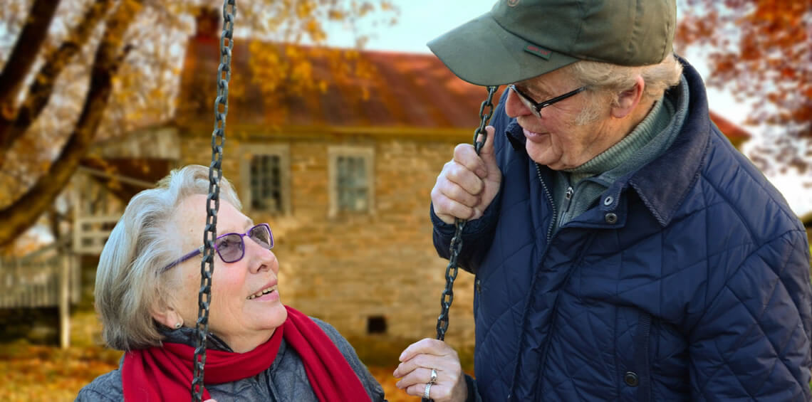 Older couple connecting on swing set