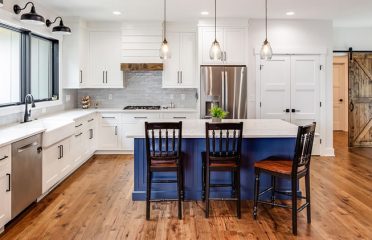 Farmhouse kitchen with blue island and white cabinets thumb