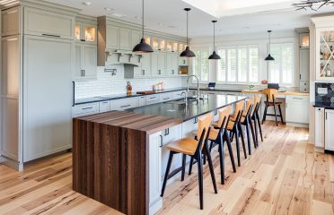 full kitchen with wood floor, island and windows angle