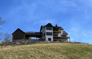 Front of house up a hill with blue sky