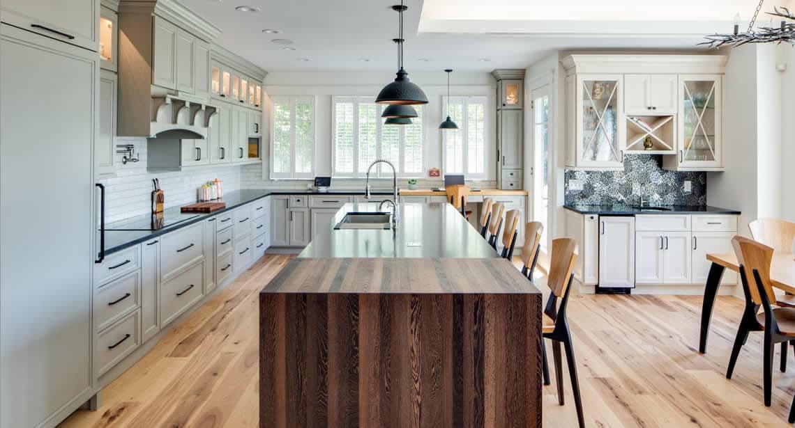 White kitchen with gorgeous light wood floors and dark island